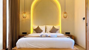 Une chambre d’hôtel avec un grand lit, deux tables de chevet, un panneau de commande fixé au mur et un plancher en bois.