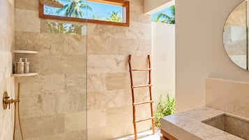 Une salle de bain moderne avec une douche à parois de verre, une échelle en bois et un plan de toilette en marbre.