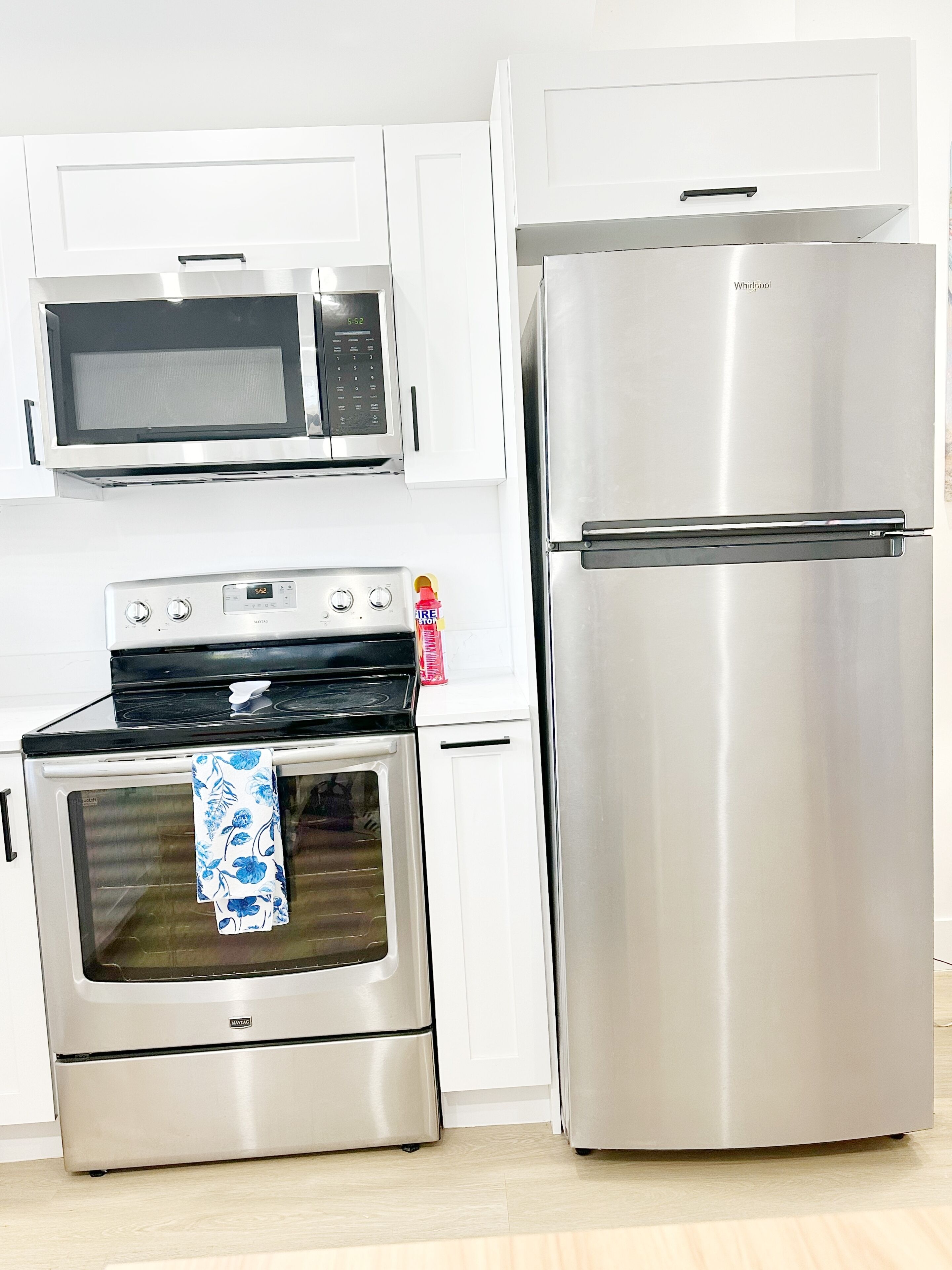 A kitchen with a microwave, oven, and refrigerator.