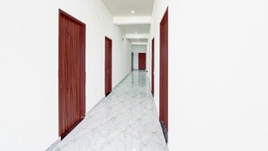 A corridor with wooden doors and white walls. - Deluxe Hotel Lara Heritage (Amer)