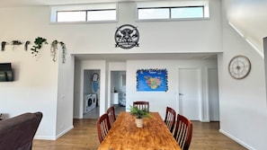 Un comedor con una mesa de madera, sillas y un mapa de Tasmania en la pared.
