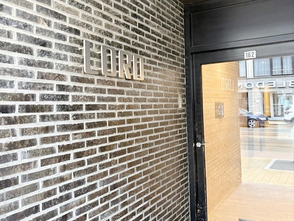 A brick wall with the word 'LORD' and a door with a number '162' visible. - Cozy Coastal Apartment With Dual Terraces (Middelkerke)