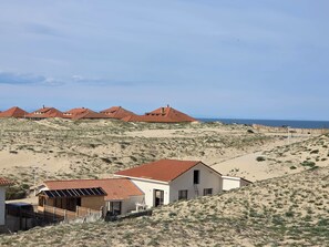 Eine Küstenlandschaft mit Sand und Häusern mit roten Dächern.