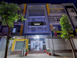 A multi-story building with a 'TOWNHOUSE' sign, potted plants, and a covered entrance.