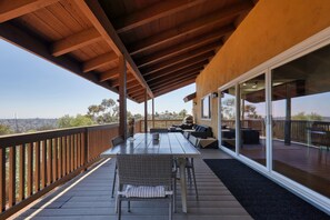 Une terrasse extérieure couverte, équipée d’une table et de chaises, d’un canapé et d’un espace barbecue.