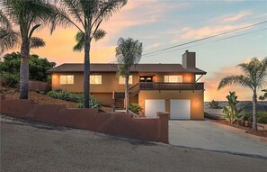 Une maison à deux étages avec un balcon, un garage et une allée.