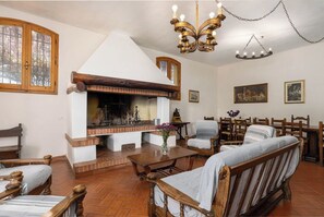 A traditional interior with a fireplace, wooden furniture, and a chandelier. - Il Leccio, Vinci by Geco Vacation Rentals (Vinci)