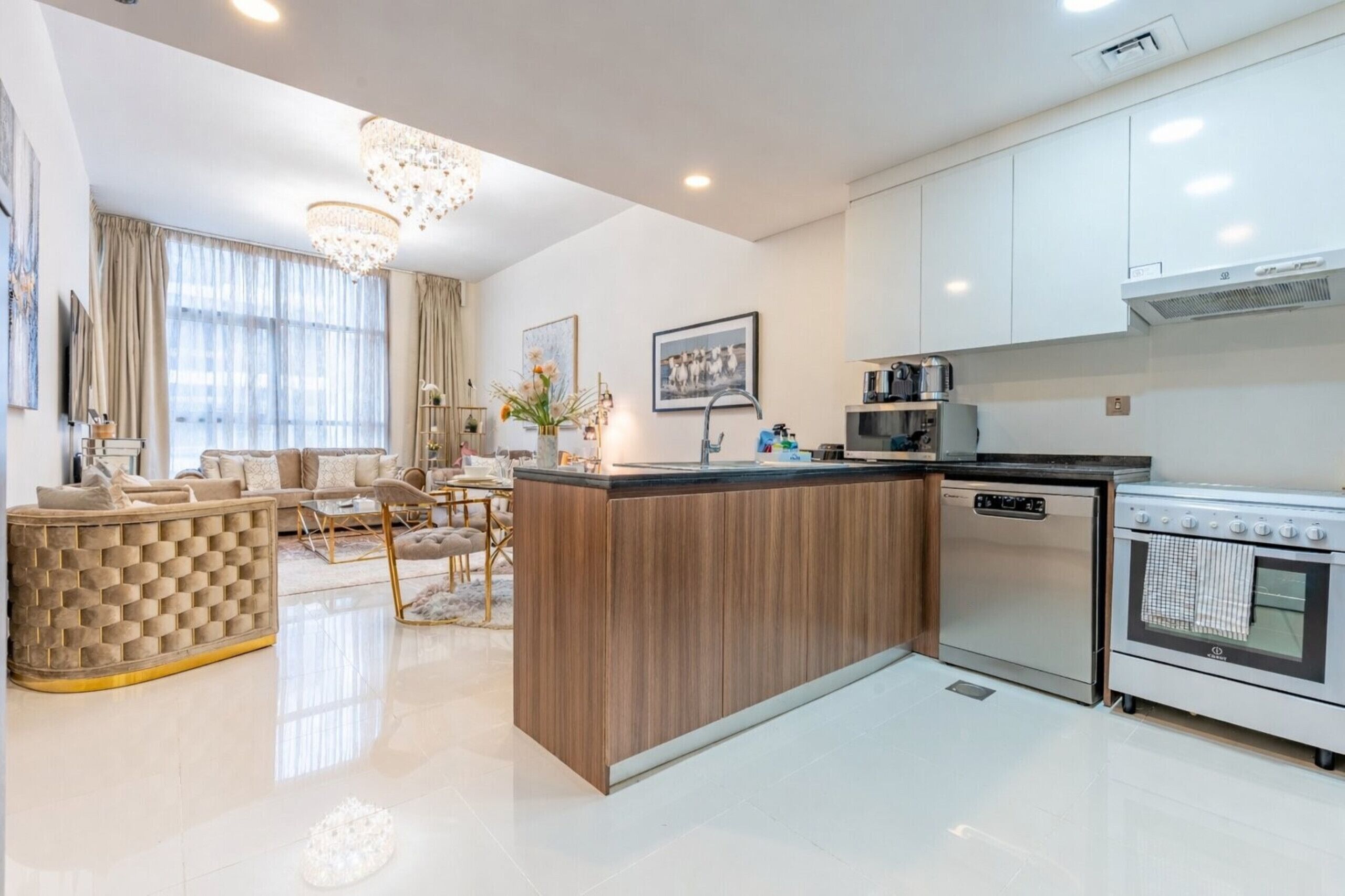 Una cocina moderna con una isla central, electrodomésticos integrados y un comedor con sofá y sillas.