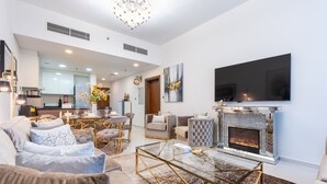 Ein modernes Wohnzimmer mit Kamin, gemütlicher Sitzecke, Essbereich und einer Küche im Hintergrund.