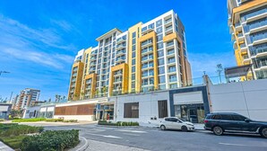 A modern multi-story building with a flat roof, large windows, and a flat facade. - Cozy Modern Studio Just A Quick Drive from Meydan Racecourse, Azizi Riviera 20 (Dubai)