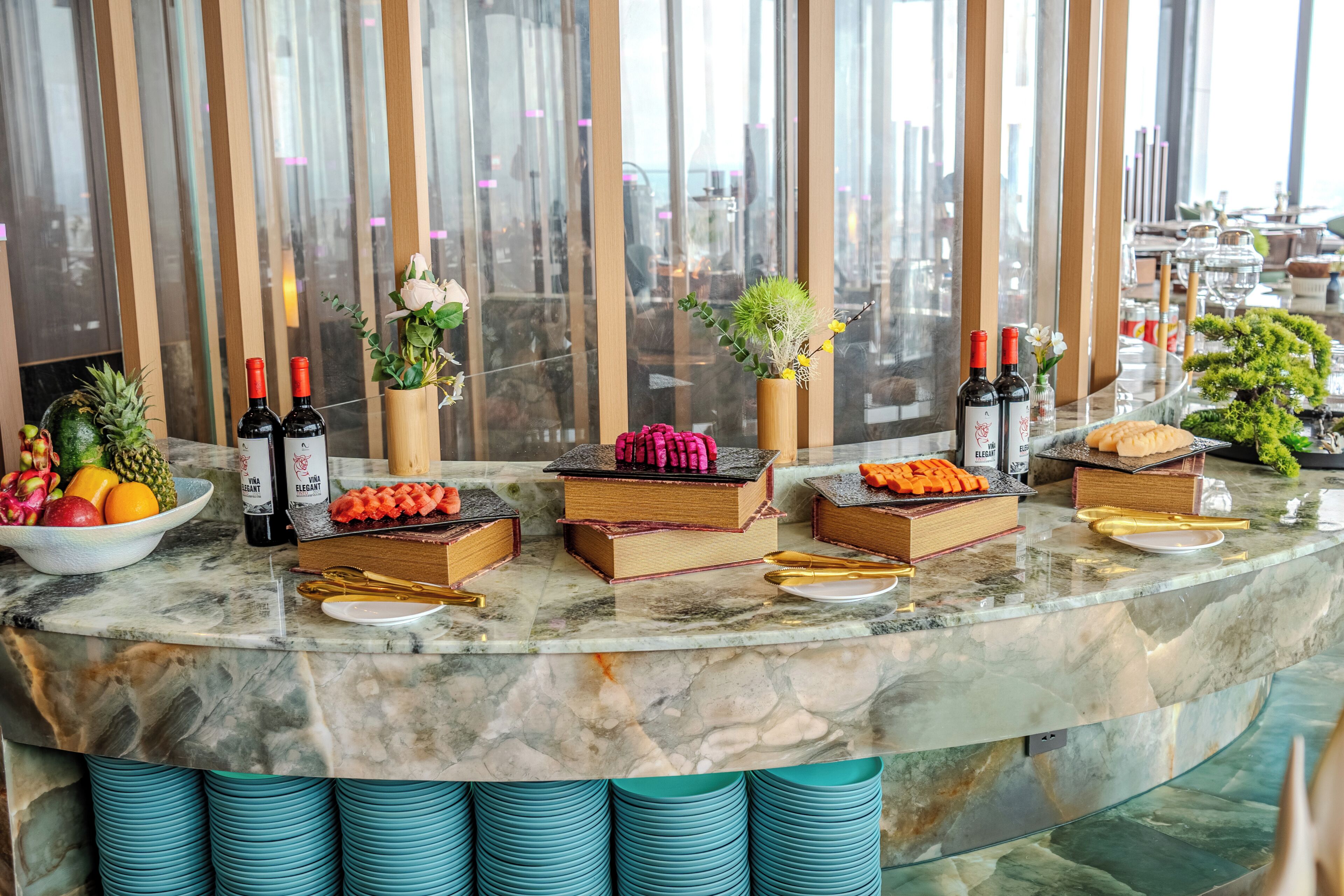 A marble bar with bottles, fruits, and decorative items.