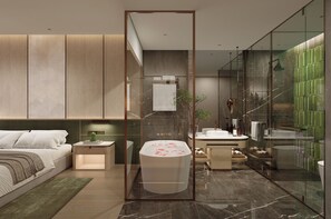 A modern bedroom with a large bed, bedside table, and a glass-enclosed bathroom with a bathtub, sink, and shower. - Steigenberger Phnom Penh (Phnom Penh)