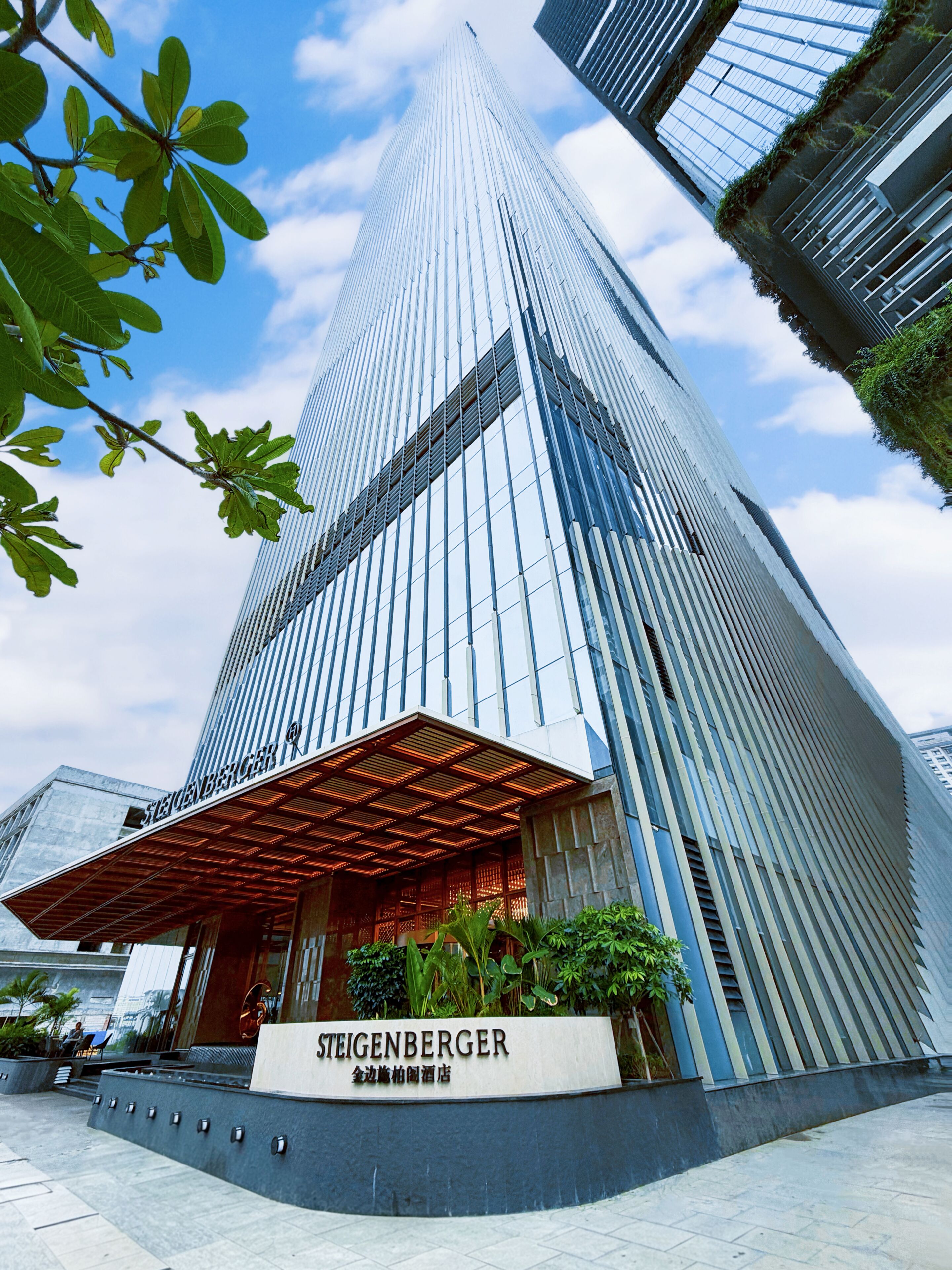 A modern high-rise hotel with a prominent entrance, large glass windows, and a sign reading 'STEIGENBERGER.'
