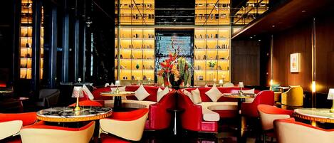 A modern interior with a central seating area, a bookshelf, and a decorative vase.