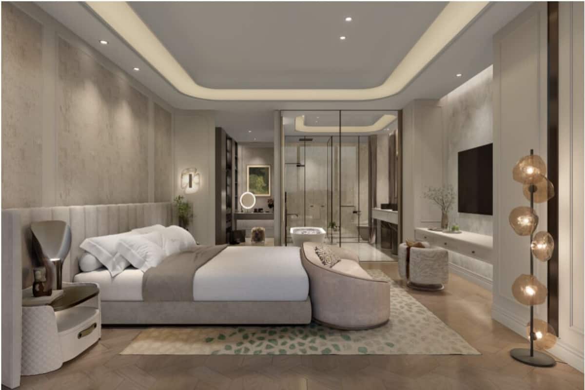 Un dormitorio moderno con una cama grande, mesitas de noche, televisor y una lámpara de pie.