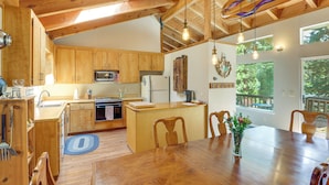 A wooden kitchen with a central island, wooden cabinets, a microwave, and a refrigerator. - Near Beaches & Boat Launches! Lake Almanor Getaway (Lake Almanor)