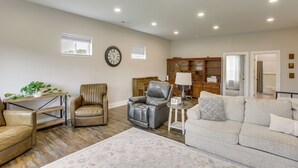 A spacious living room with a leather sofa, a leather armchair, a small table with a lamp, and a decorative rug. - Sunset Soaks & Family Fun: Rural Tennessee Retreat (Bethpage)