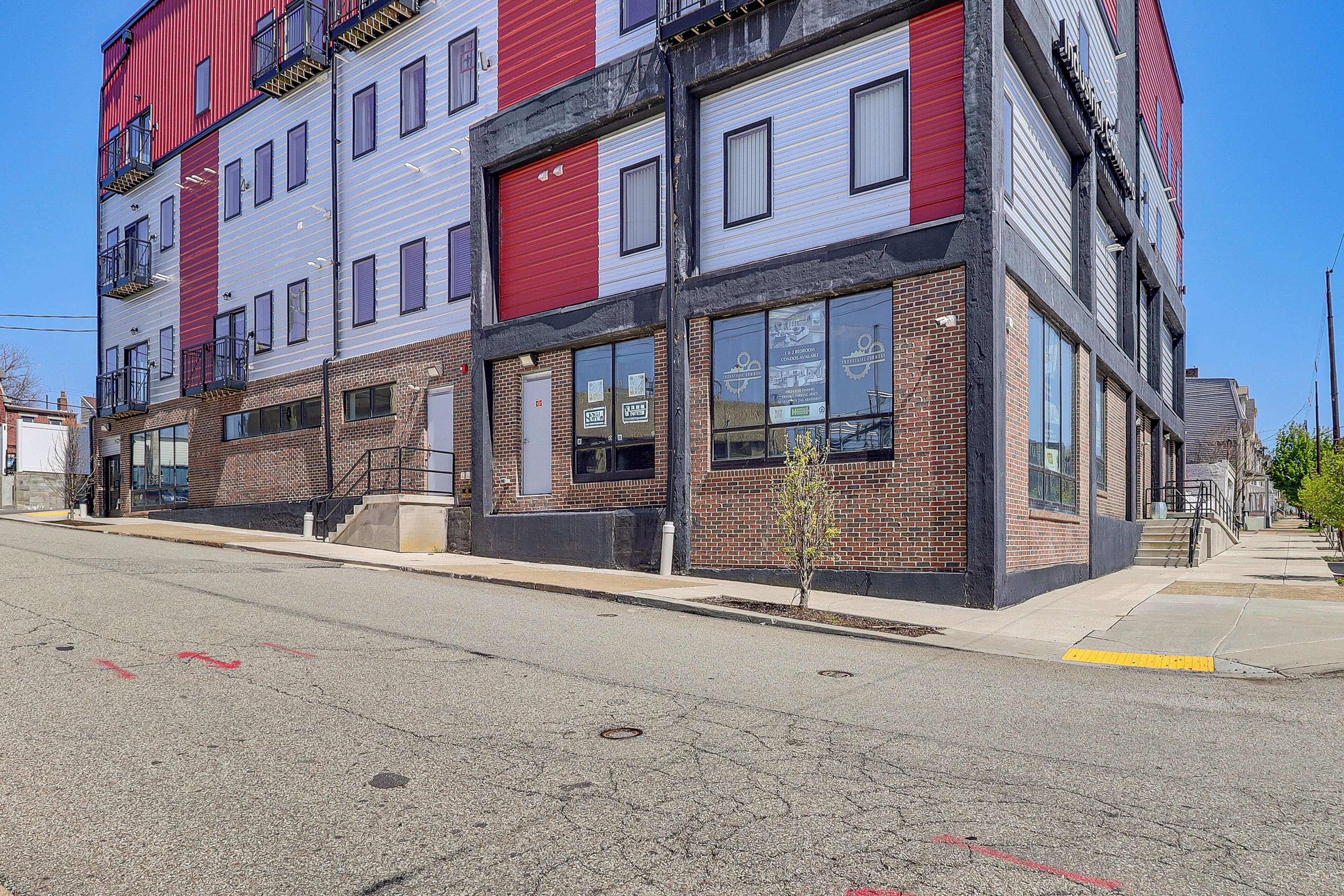 A multi-story building with a brick facade, large windows, and a fire escape.