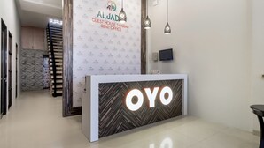 A hotel reception desk with a logo, a sign for the guest house, and a modern interior design. - Cozy Double Escape W/ Free WiFi and Parking (Medan)