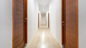 Un pasillo con puertas de madera y piso de color claro.