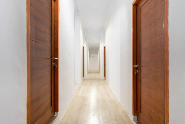 Un pasillo con puertas de madera y piso de color claro.