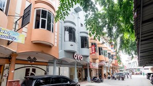 Una calle con un edificio identificado como 'OYO' y un letrero que indica 'Servicio de Lavandería'.