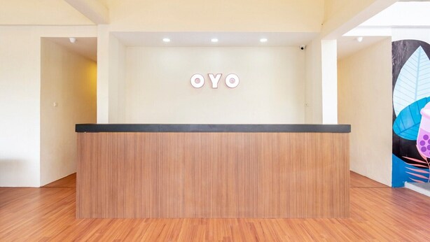 A reception desk with a wooden finish and a black top. - Cozy Double Escape W/ Free WiFi and Parking (Medan)