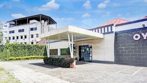 A hotel entrance with a covered walkway, a building with a sign, and a hedge. - Luxury Deluxe DBL Retreat W/ Free WiFi and Parking (Medan)