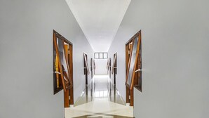 Un long couloir étroit, doté d’un plancher ciré et de portes en bois de chaque côté.