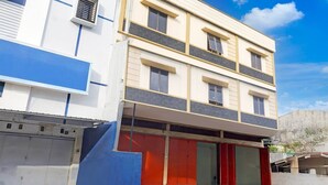 Ein mehrstöckiges Gebäude mit einer glatten Fassade, großen Fenstern und einer roten Garagentür.