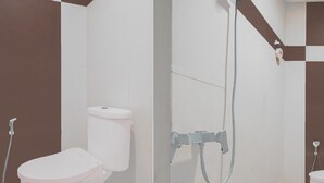 Une salle de bain équipée de toilettes, d’une douche et d’un bidet.