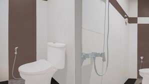 A bathroom with a toilet, a shower, and a bidet.