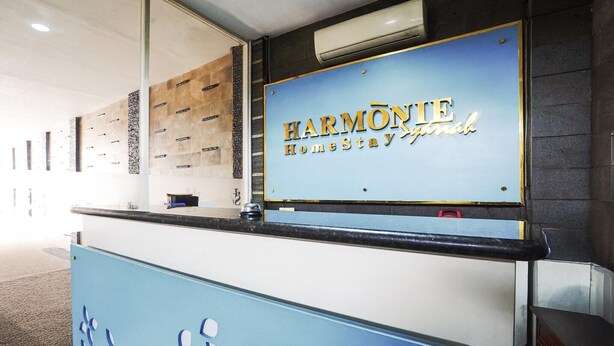 A reception desk with a sign that reads 'HARMONIE Homestay.'
