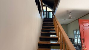 A wooden staircase with a red door at the bottom. - The Amar Vilas (Dehradun)