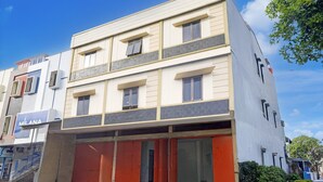 A multi-story building with a flat facade, large windows, and a visible storefront with a sign. - Luxury Twin Stay with Free WiFi and Parking (Makassar)