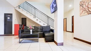 A living room with a sofa, coffee table, and a staircase. - Luxury Twin Stay with Free WiFi and Parking (Makassar)