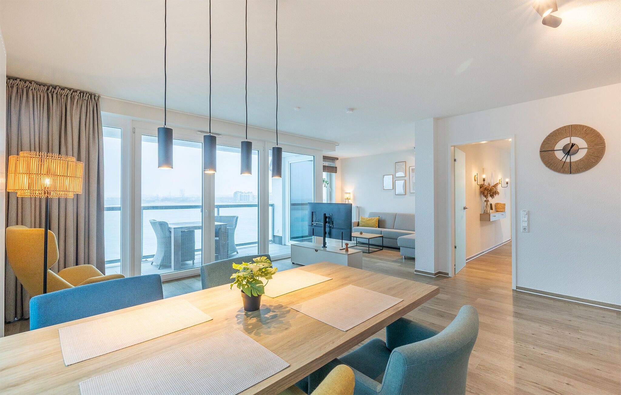 A modern hotel room with a dining area, a living space, and a view of the city.