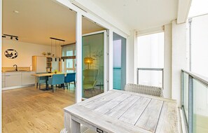 Eine moderne Küche mit Essbereich, einem großen Fenster und einer Glastür, die auf einen Balkon führt.