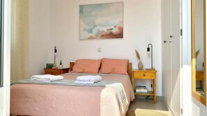 Un dormitorio con cama, mesitas de noche, una obra de arte en la pared y un armario de madera.