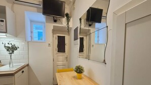 Une cuisine compacte avec une table en bois, une petite plante en pot et une fenêtre donnant sur un beau paysage.