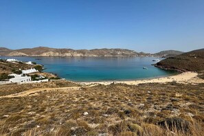 Eine Küstenlandschaft mit Strand, einem kleinen weißen Gebäude und einem klaren, blauen Meer.