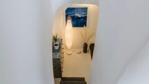 A staircase with a wall-mounted light fixture, a framed artwork, and a small potted plant. - Dionysos Wine Stay, Mountain Views (Emporeio)