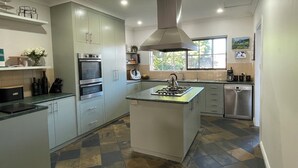 A modern kitchen with a central island, built-in oven, and stainless steel appliances. - Beach and Winery getaway. The perfect base for a family holiday. Pet friendly (Seaford)
