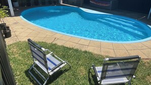 A swimming pool with two lounge chairs, a covered patio area, and a fenced backyard. - Beach and Winery getaway. The perfect base for a family holiday. Pet friendly (Seaford)