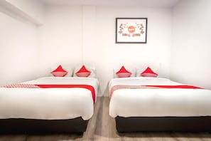Ein Hotelzimmer mit zwei Betten, jeweils mit rot-weiß gestreifter Bettwäsche, einem gerahmten Bild an der Wand und einem Holzboden.