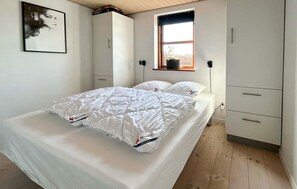 A bedroom with a bed, a window, a wardrobe, and a painting on the wall. - Lovely home in Haderslev with sauna (Haderslev)
