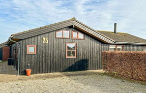 A wooden building with a number '25' on the side, a gravel driveway, and a hedge. - Lovely home in Haderslev with sauna (Haderslev)