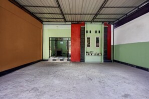 A hallway with a tiled floor, a green door, and a red pillar.