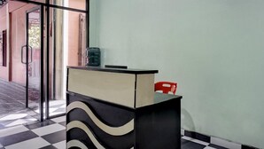 Eine Rezeption mit Check-in-Schalter, Glastür und Schachbrettmuster auf dem Boden.