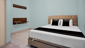 Ein Schlafzimmer mit Bett, Ablagefläche und Tür.